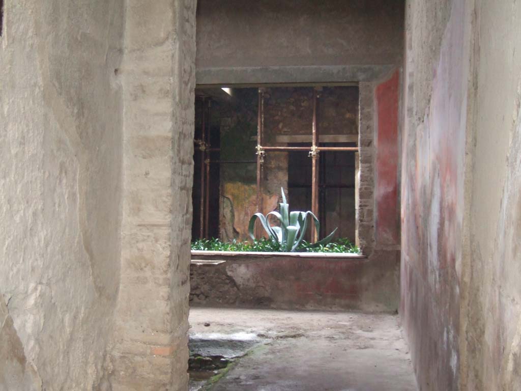 I.7.3 Pompeii. December 2005. Looking south along west side of atrium to small garden.
According to Jashemski, in the light-well or small garden at the rear of the atrium, was a small raised flower bed.
In the bed was a tiny semi-circular pool, which was fed by roof water.
There were three marble bases which were probably placed at the edge of the pool.
On the south wall behind the small garden was a garden painting.
See Jashemski, W. F., 1993. The Gardens of Pompeii, Volume II: Appendices. New York: Caratzas. (p.37, with fig.36)
A description of the garden painting is given on page 316, no. 7.