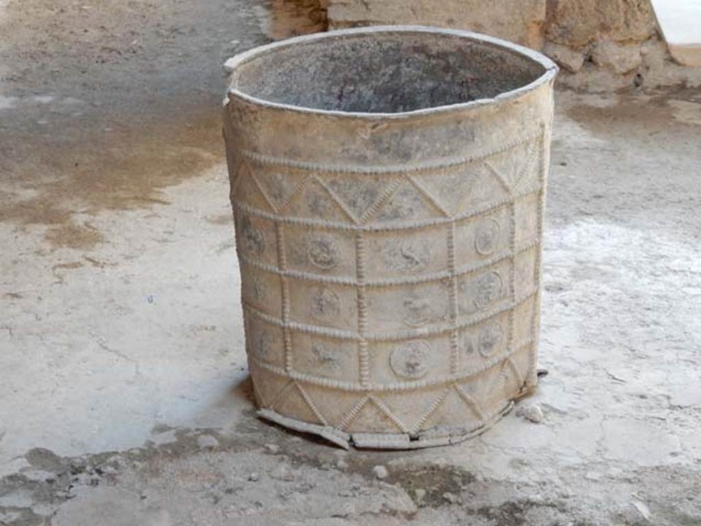 I.7.3 Pompeii. May 2016. Laminated cylindrical lead bucket with relief of zodiac signs, in atrium. Photo courtesy of Buzz Ferebee.