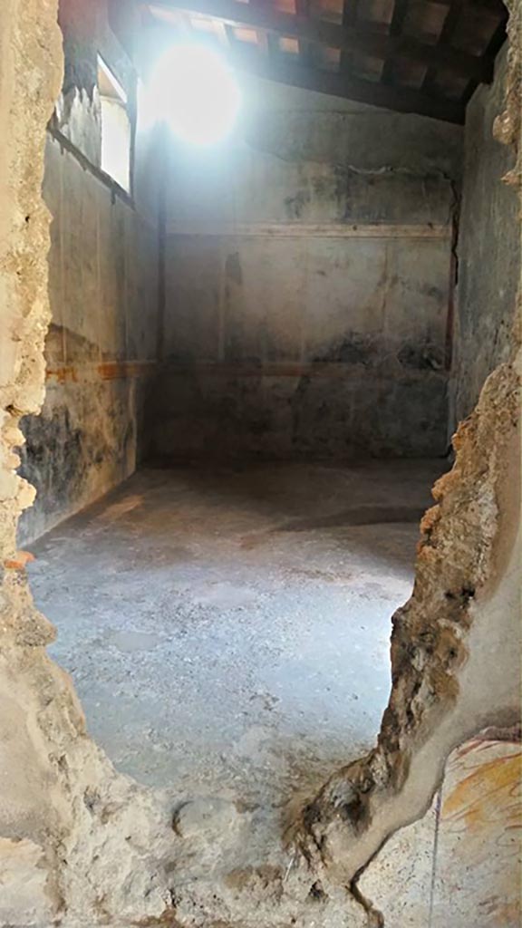 I.7.11 Pompeii. 2015/2016.
Looking through hole in south wall of cubiculum, into triclinium. Photo courtesy of Giuseppe Ciaramella.
