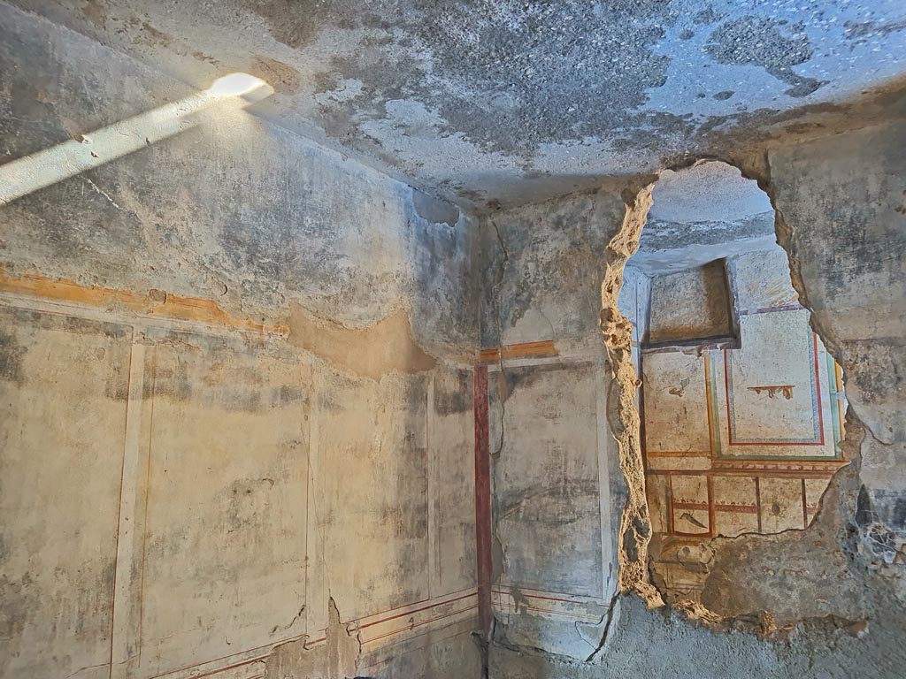 I.7.11 Pompeii. March 2024.
Looking north along east wall into north-east corner and north wall with hole through into cubiculum. Photo courtesy of Giuseppe Ciaramella.