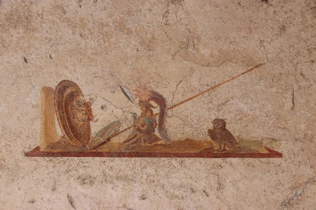 I.7.11 Pompeii. September 2021.
Detail of wall painting of the attributes of Minerva/Athena in centre panel of north wall. Photo courtesy of Klaus Heese.