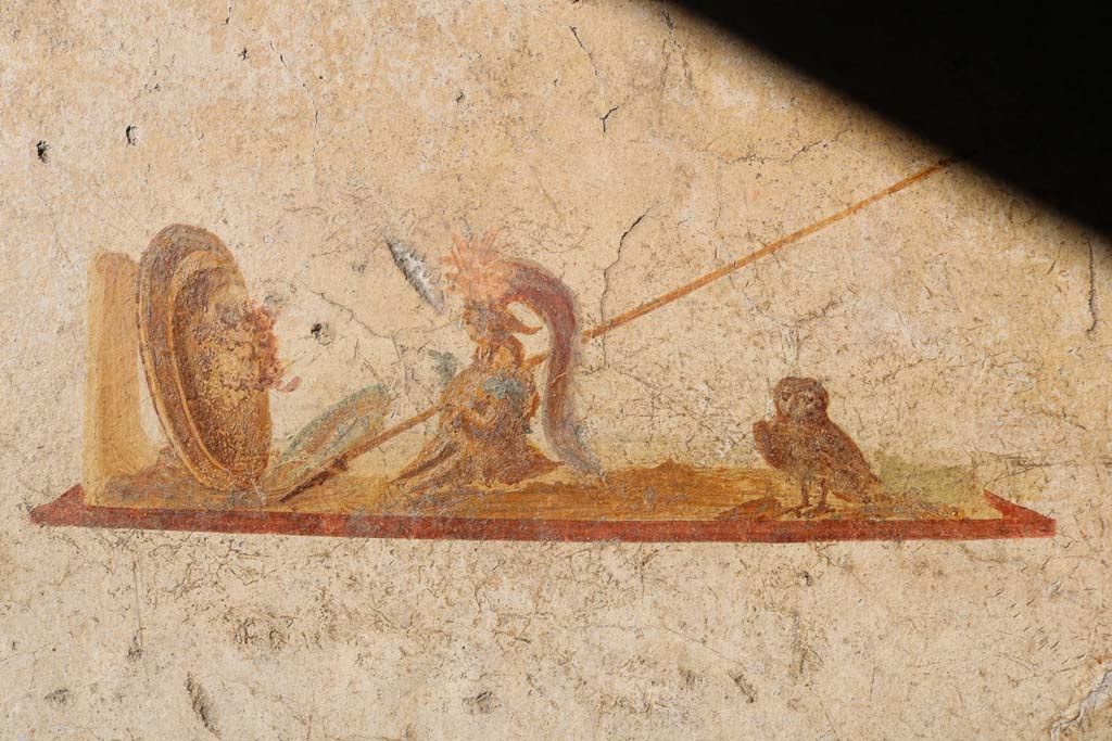 I.7.11 Pompeii. December 2018.
Detail of wall painting of the attributes of Minerva/Athena in centre panel of north wall. Photo courtesy of Aude Durand.