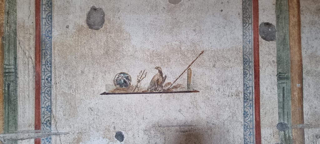 I.7.11 Pompeii. December 2023.
Wall painting of the attributes of Jupiter, from centre panel of east wall in cubiculum. Photo courtesy of Miriam Colomer.