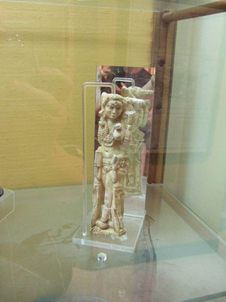 I.8.5 Pompeii. Ivory statuette of Lakshmi. Found in a wooden chest on the west side of the Viridarium 8. Now in Naples Archaeological Museum. Inventory number 149425. According to Jashemski, Della Corte stated that the small Indian statuette was found October 24th 1938 in the nearby I.8.19. He thought it had been thrown down, when the south-west corner of the peristyle of this house had collapsed. Maiuri said that the statuette had been stored in a wooden chest in one of the rustic rooms off the portico, together with various objects of domestic use.
Maiuri “Statuette eburnean d’arte Indiana a Pompeii, Le arti (1938) pp 111-115. Della Corte, M., 1965. Case ed Abitanti di Pompei. Napoli: Fausto Fiorentino.(p.333-4). See Jashemski, W. F., 1993. The Gardens of Pompeii, Volume II: Appendices. New York: Caratzas. (p.42)
According to Berry, the statuette was found in the House of the Four Styles (I.8.17). See Berry, J., 2007. The Complete Pompeii. London, Thames & Hudson, (p.200)