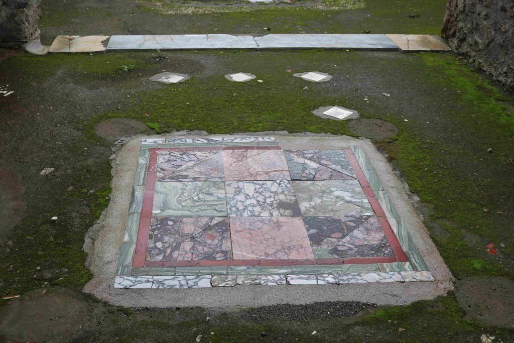 I.8.9 Pompeii. December 2018. Room 2, oecus, looking south across flooring.
Emblema in opus sectile of coloured marble in centre of floor, with remains of white marble diamond shaped pieces. Photo courtesy of Aude Durand.