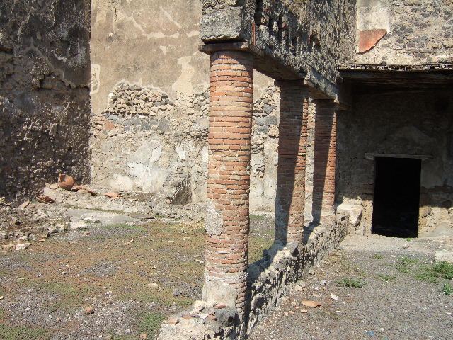 I.8.10 Pompeii. March 2009. Area on east side of niche. Remains of painting of a Lar. There was one lar on either side of the niche. See Fröhlich, T., 1991. Lararien und Fassadenbilder in den Vesuvstädten. Mainz: von Zabern. (L9: p.253, T25.2).