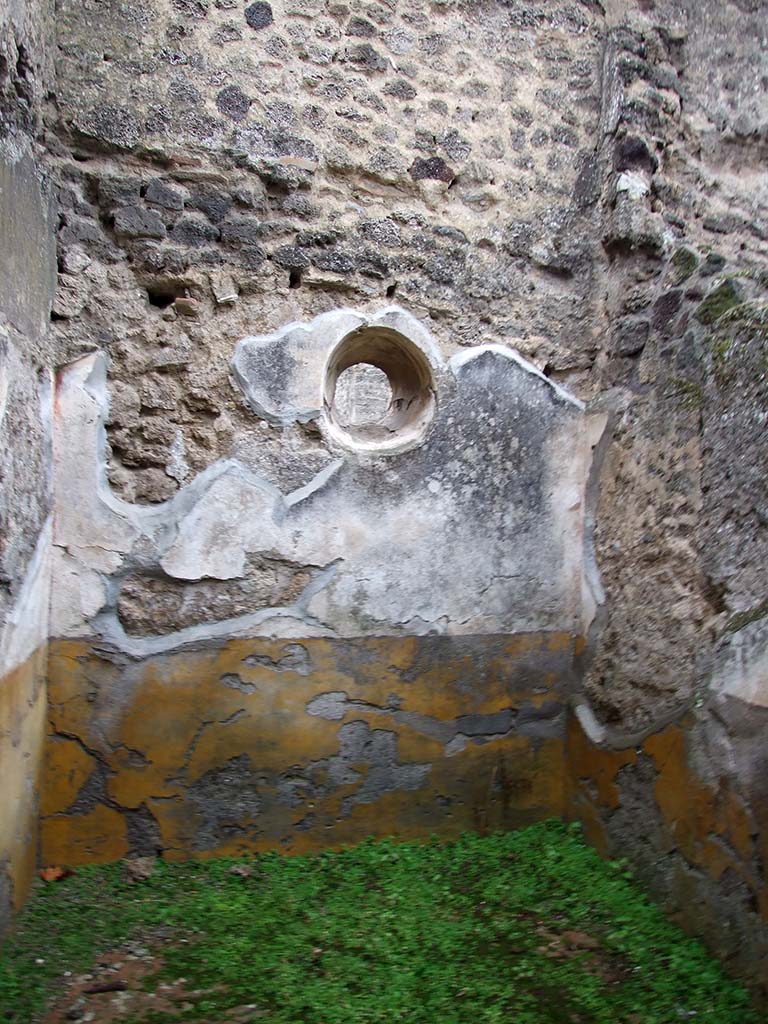I.8.14 Pompeii. December 2007. Room 5, east wall of cubiculum with circular window.
The high zoccolo was yellow, and the middle zone of the wall was white showing vignettes with “carpet borders” in the panels separated by compartments painted with golden candelabra.
See/Vedi Carratelli, G. P., 1990-2003. Pompei: Pitture e Mosaici: Vol. I. Roma: Istituto della enciclopedia italiana, p. 838.