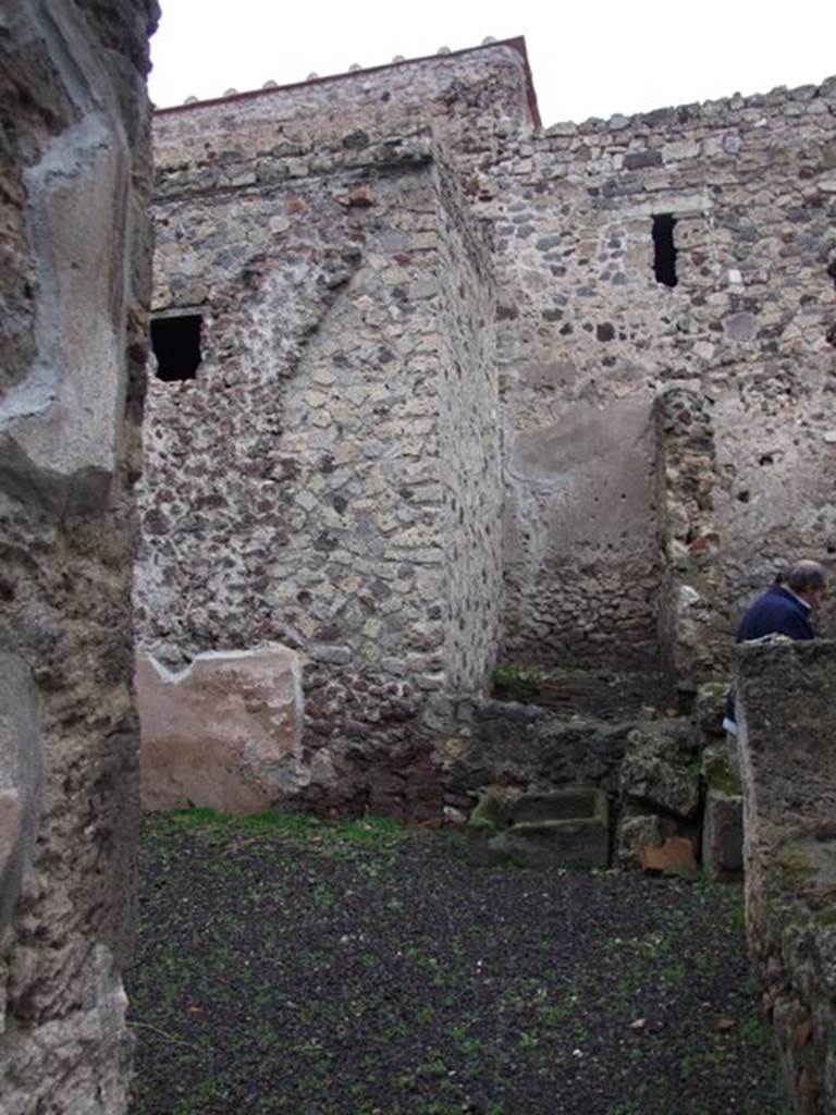 I.8.14 Pompeii. December 2007.
Room 7, courtyard area, looking north through doorway from atrium towards north-east corner of courtyard.
At the rear of the fallen wall is the latrine (11).