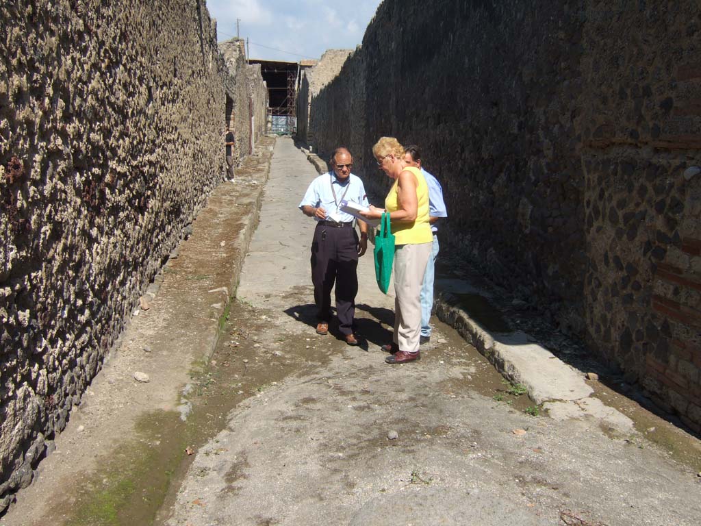 I.8 Pompeii, on left. September 2005. Roadway looking north. Side wall of I.9.14, on right.