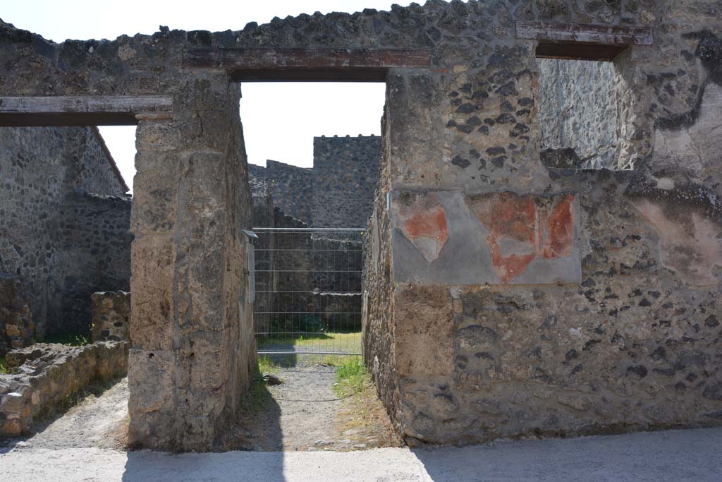 I.10.3 Pompeii. March 2009. Niche on east wall of fauces. According to Boyce, this shallow arched niche was painted white like the walls of the room, but coated with a finer stucco. A marble slab formed its floor.
Above the painted round altar in crude red letters was the graffito CIL IV 7339. Beneath the slab of marble which formed the floor of the niche was scratched; LARES AVGVSTOS.  [CIL IV 8282 – Lares Augustos]
Not. Scavi, 1934, 271 and fig.5. See Boyce G. K., 1937. Corpus of the Lararia of Pompeii. Rome: MAAR 14. (p.27, no.47, with Pl.14, 2) 

