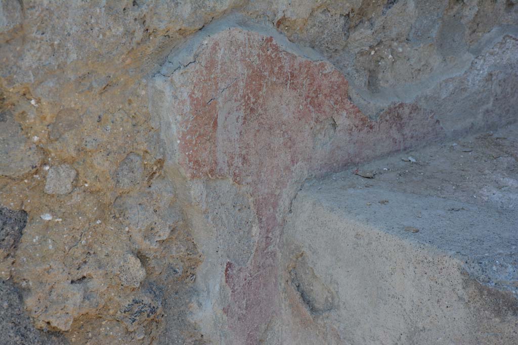I.10.18 Pompeii. April 2017. Detail of remaining painted plaster at rear of bench seating on south side of entrance doorway.
Photo courtesy Adrian Hielscher.