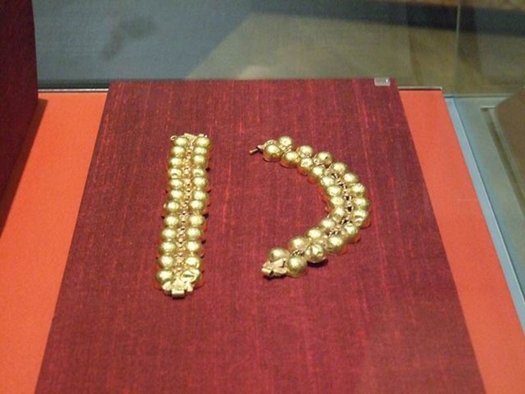I.11.6 Pompeii. Two gold bracelets with twelve pairs of hemispheres linked together by articulated links with a cylindrical body.
Found in a bronze arca (chest) in the south-east corner of the atrium.
SAP 10759a and 10759b.
Photographed at “A Day in Pompeii” exhibition at Melbourne Museum. September 2009.
See Mileti M. C., 2000. La casa I, 11, 6-7 a Pompeii: Rivista di Studi Pompeiani XI, p. 110.