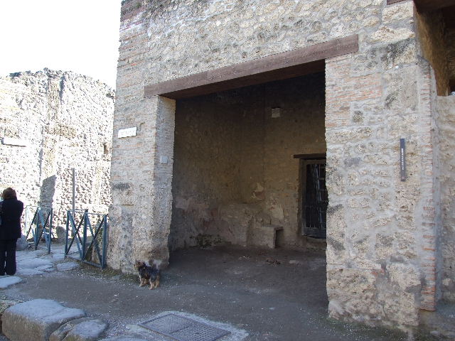 I.11.7 Pompeii. May 2005. Looking south towards corner with shop and back room. On the north-east corner of insula, there was a masonry ara compitalis, now almost destroyed.
