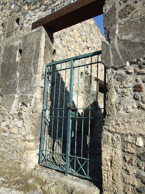 I.11.15 Pompeii. December 2007. Room 2,  storeroom with latrine on north side of entrance. Originally this room would have had a doorway into the atrium, the join in the wall can be seen towards the right. 
