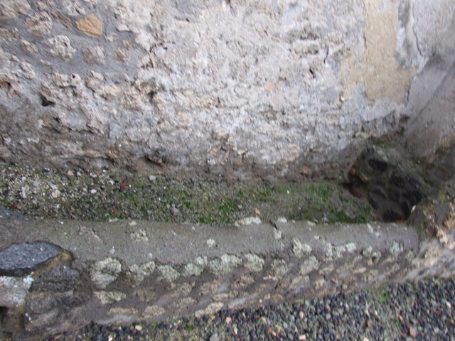 I.11.15 Pompeii. December 2006. Remains of low wall of room 3 on south side of entrance.