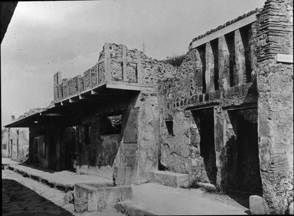 I.12.1 and I.12.2 Pompeii, on right.  Entrances on Via dell� Abbondanza, with fountain outside. Looking east. Photo by permission of the Institute of Archaeology, University of Oxford. File name instarchbx202im 001. Resource ID. 44520.
