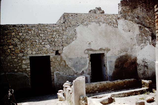 I.12.8 Pompeii. March 2009. Room 9, north-west corner showing five of the six dolia found here. The sixth stands near the latrine in the north-east corner of the peristyle garden.
According to Curtis, five of these containers held the remains of a fish sauce, garum or liquamen. Garum was the product formed from the self-maceration of fish and other small marine animals in salt. Liquamen was a closely related fish sauce.
Several of the amphorae that were also found here also contained a substance similar to that found in the dolia. Maiuri stated that when these vessels were excavated the smell of fish was still fresh. This smell remained strong for some time after the exposure to the air.
The dried fish sauce contained the small bones and vertebrae of anchovies. Although the clear liquid had long since dried up, it left the odour entrapped until released in 1960.
See Curtis, R.I: The Garum shop at Pompeii, In Cronache Pompeiane, V,1979, (p.10)
See Maiuri, A: L’odore della salsa di 2000 anni fa, In Corriere della Sera (Milan), 2 January 1961, p.3