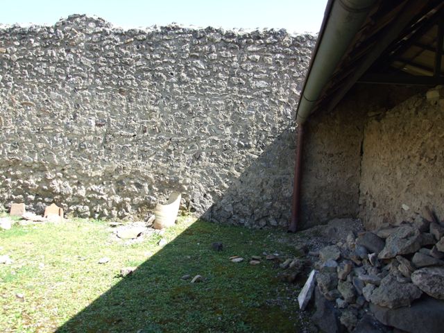 I.12.8 Pompeii. March 2009. Room 13, looking west in rear garden.  According to Curtis, on Eschebach’s 1969 plan of the house is shown an entrance doorway from the rear garden courtyard leading into the house at I.12.7.  This is an error.  See Curtis R.L: The Garum shop of Pompeii, In Cronache Pompeiane, V.1979, p.8 note 5.
