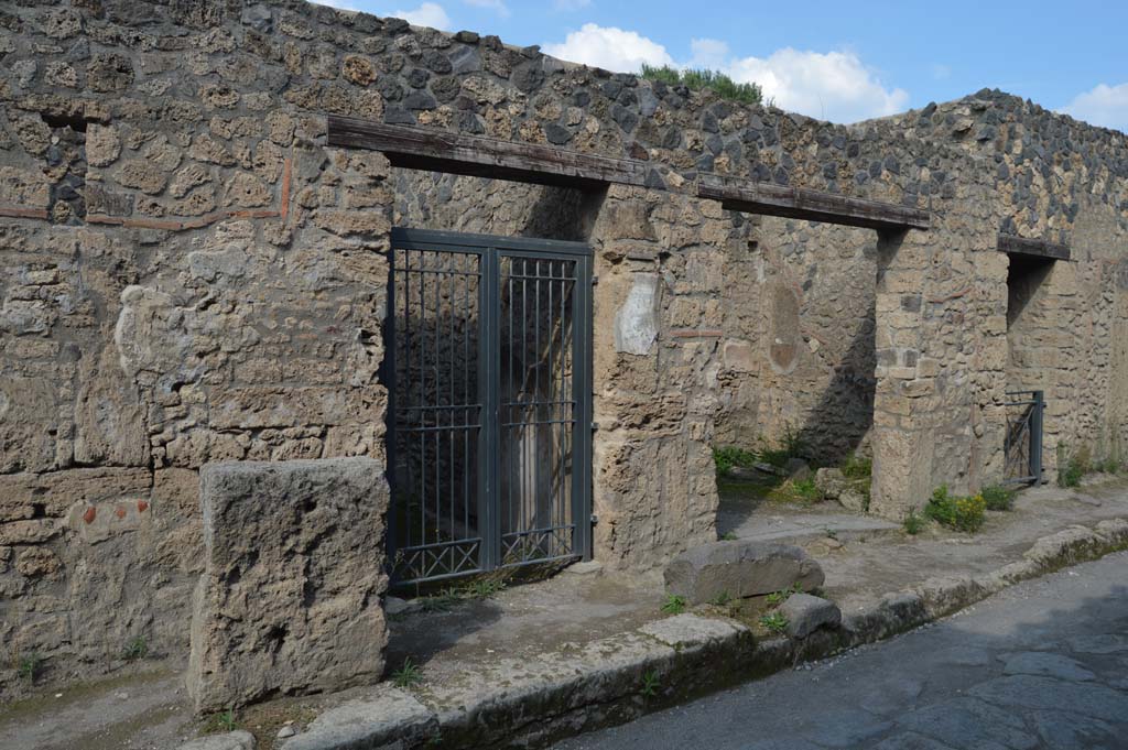 I.12.11 Pompeii, on left. October 2018. 
Looking north-east to entrance doorways, with I.12.10 and I.12.9, on right, on north side of Via di Castricio.
Foto Taylor Lauritsen, ERC Grant 681269 D�COR.

