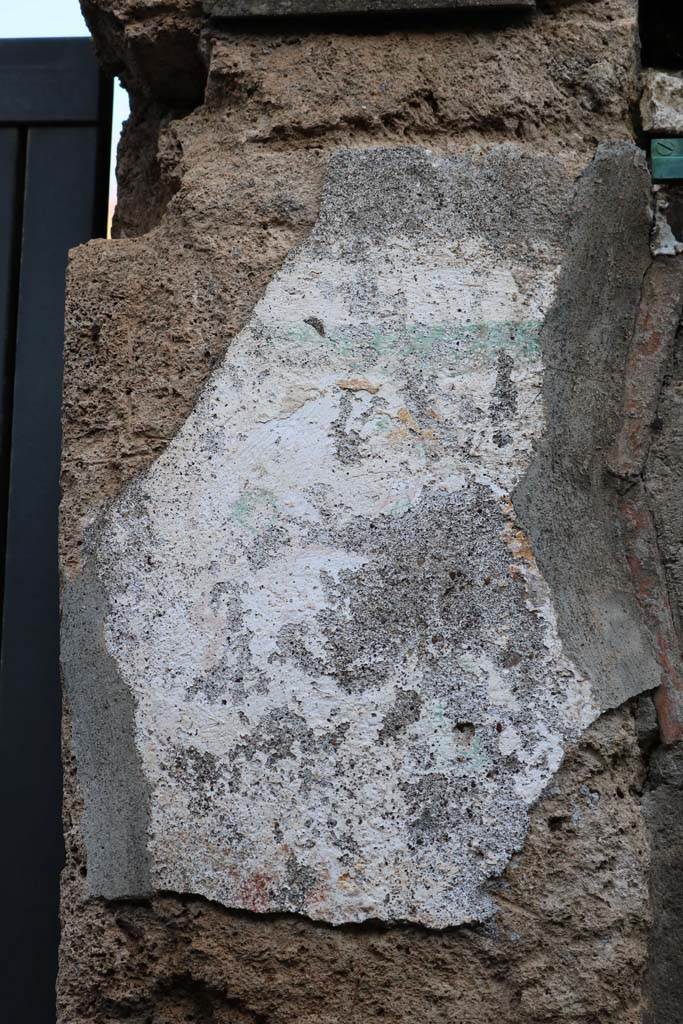 I.12.11 Pompeii. December 2018. Pilaster on east of entrance doorway, site of wall painting of Hercules.
Remains of painted plaster on east side of doorway, the remains of the �garland� are just visible.
Photo courtesy of Aude Durand.

