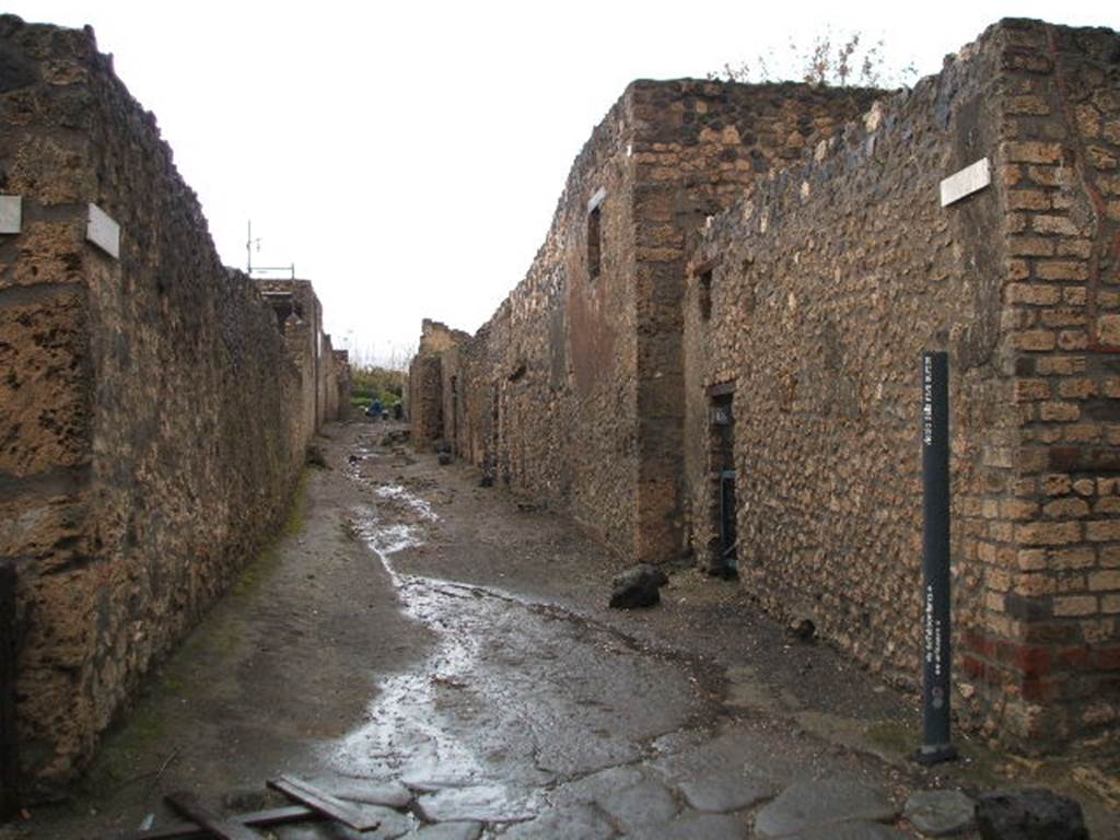 I.11 Pompeii. December 2004. Roadway looking north, showing I.12.13 and side wall of I.12.12