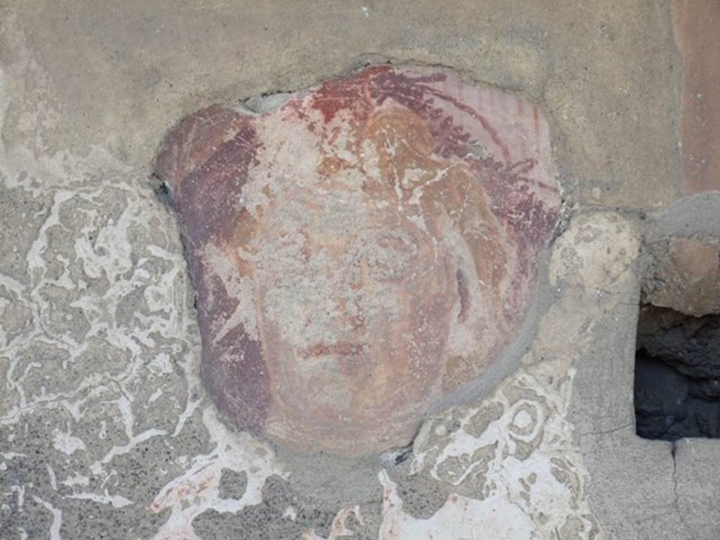 I.12.15 Pompeii. March 2009. Room 5, lararium. Detail of a face on north side of the niche on the east wall.
