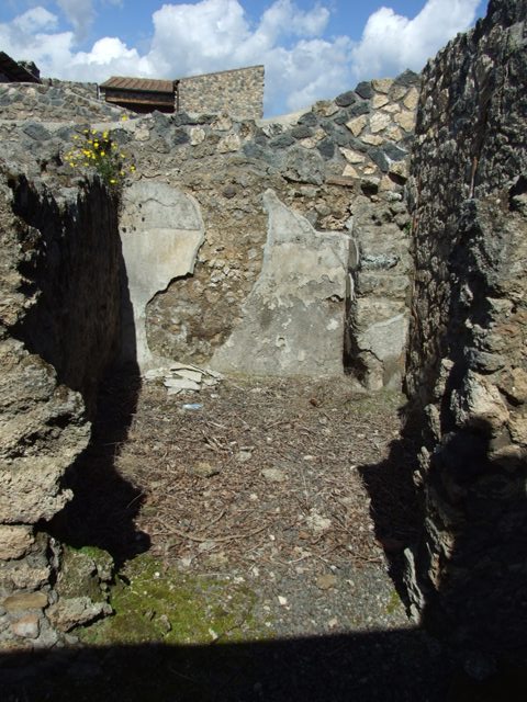 I.12.15 Pompeii.  March 2009.  Square masonry base in south east corner outside room 6.