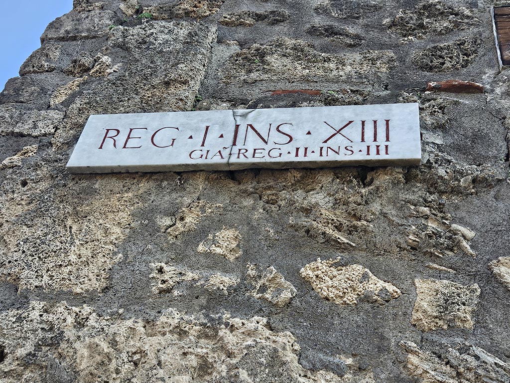 I.13.5 Pompeii. November 2024.
Insula identification plaque on east side of doorway, originally known as Reg. II, Insula III. Photo courtesy of Annette Haug.