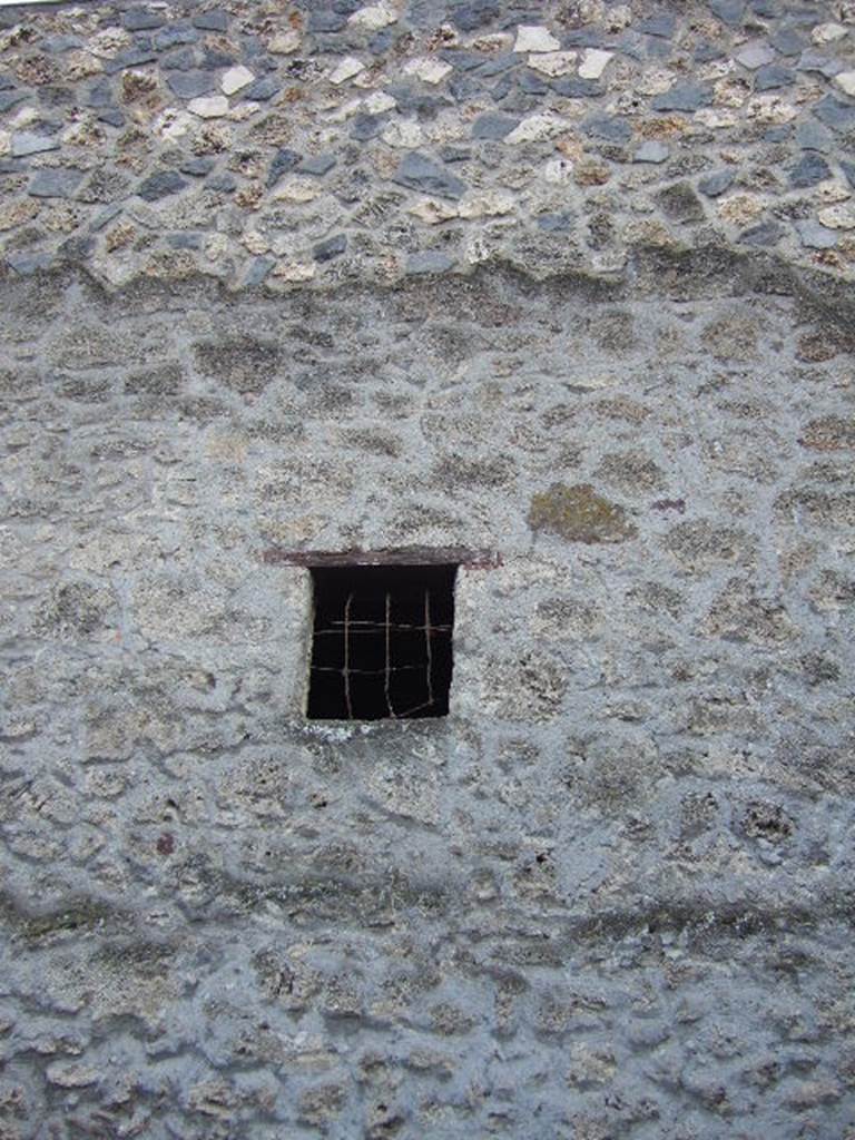 I.13.5 Pompeii. December 2005. Outside view of window with metal grate in side wall on Via di Nocera.