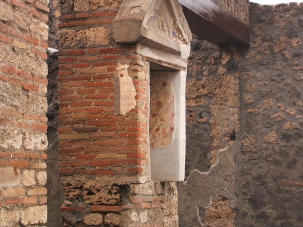 I.13.12 Pompeii. December 2004. Lararium on west side of atrium. According to PPP, this niche and white wall were frescoed and had coloured mosaic in the tympanum. See Bragantini, de Vos, Badoni, 1981. Pitture e Pavimenti di Pompei, Parte 1. Rome: ICCD. (p.190) See Fröhlich, T., 1991. Lararien und Fassadenbilder in den Vesuvstädten. Mainz: von Zabern. (L32)