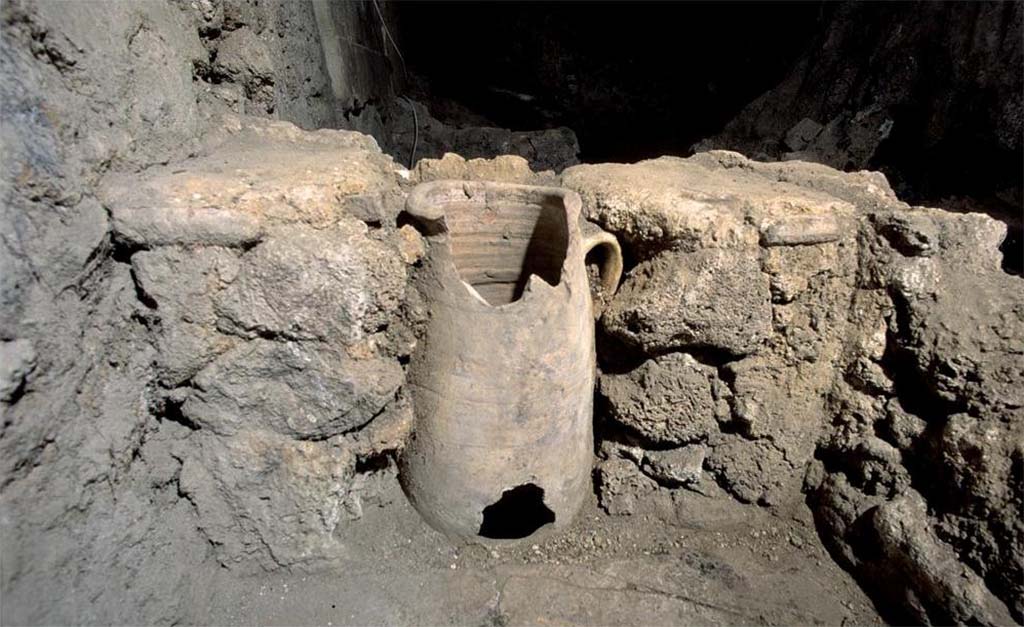 I.14.2 Pompeii. Room J, latrine in north-east corner. Amphora embedded in the bench with small opening at the base.
Fig. 179 � D�tail de la latrine : amphore encastr�e dans la banquette (� CNRS-CCJ, Christine Durand).
Voir Chapitre 2 : L�atelier de fabrication de nattes de la via di Nocera (I 14, 2) in Magali Cullin-Mingaud, 2010. La vannerie dans l'Antiquit� romaine: Collection du Centre Jean B�rard 35. Paris. Centre Jean Berard, p. 129-171, fig. 179.
https://books.openedition.org/pcjb/706  
