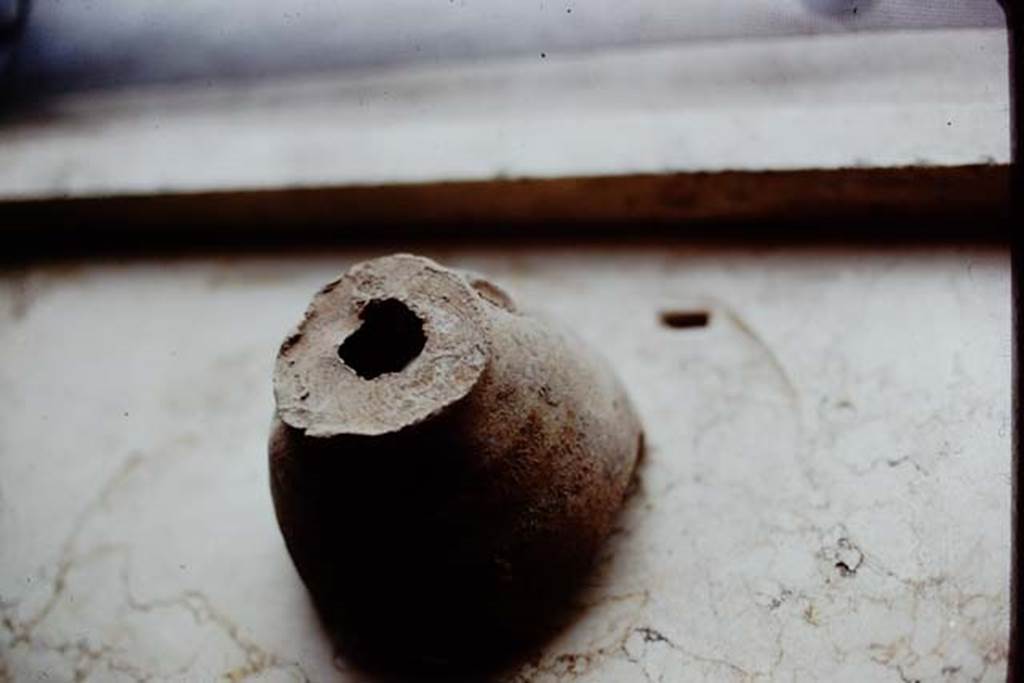 I.14.2 Pompeii. 1972. Planting pot with hole in the bottom. According to Wilhelmina, 
�Fragments of planting pots (which had been badly damaged during the original excavation of this site) were found along the north wall. These may have indicated that a few grafted trees of a special variety might have been started in these pots�. 
Photo by Stanley A. Jashemski. 
Source: The Wilhelmina and Stanley A. Jashemski archive in the University of Maryland Library, Special Collections (See collection page) and made available under the Creative Commons Attribution-Non Commercial License v.4. See Licence and use details. J72f0729
