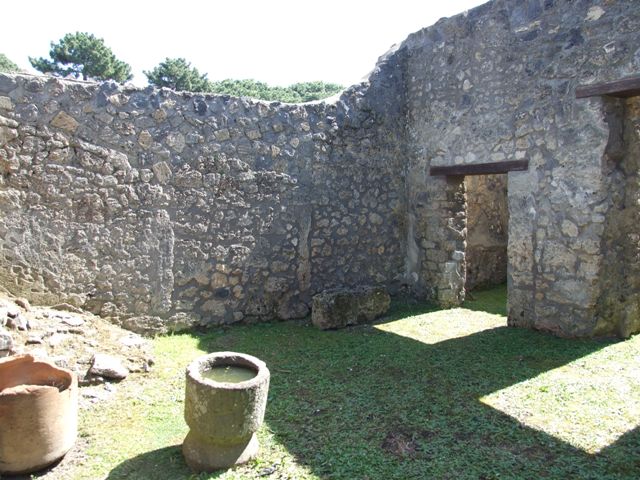 I.14.7 Pompeii. March 2009. Lararium against south wall of garden area, with water channel around base.