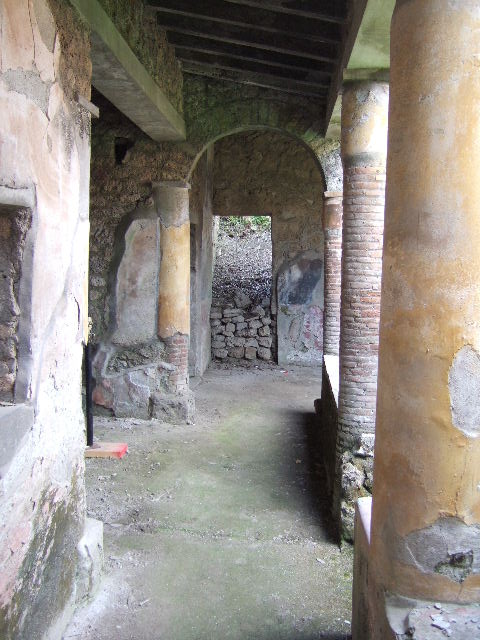 I.17.4 Pompeii. May 2006. Open area or yard on south side of peristyle garden. Looking south to stairs, with cupboard underneath, and upper gallery. The triclinium and a cubiculum are on the left.