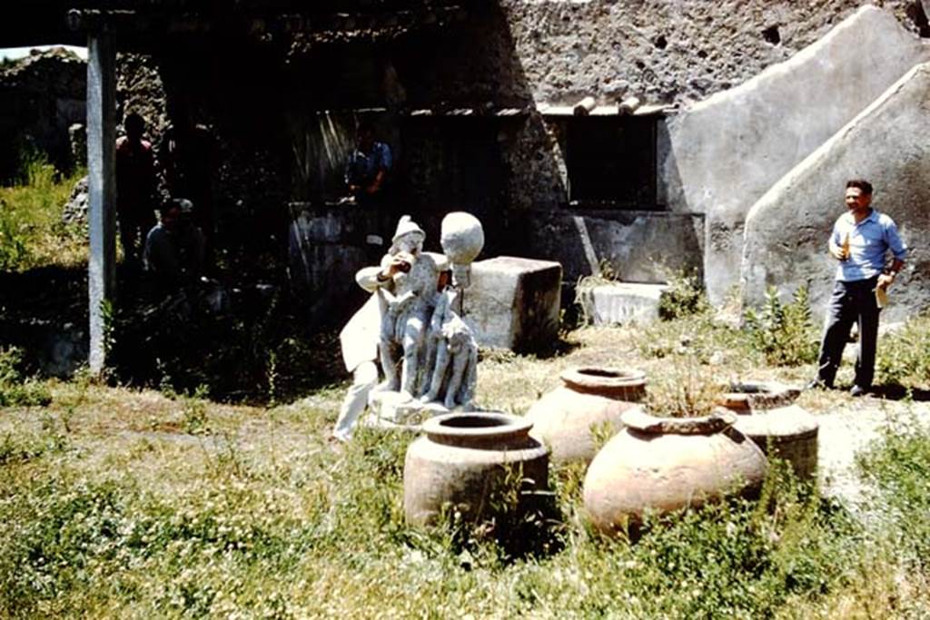 I.20.1 Pompeii. 1961. Looking north-west across garden area towards triclinium, dolia and gladiator - having a drink. Photo by Stanley A. Jashemski.
Source: The Wilhelmina and Stanley A. Jashemski archive in the University of Maryland Library, Special Collections (See collection page) and made available under the Creative Commons Attribution-Non Commercial License v.4. See Licence and use details.
J61f0469