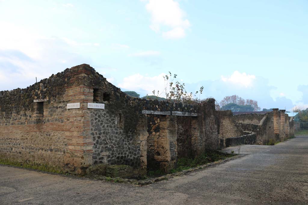 Via della Palestra, south side, Pompeii. December 2018.
Looking west from junction with Vicolo dei Fuggiaschi, on left, from I.21.5 towards I.21.1, on right. Photo courtesy of Aude Durand.