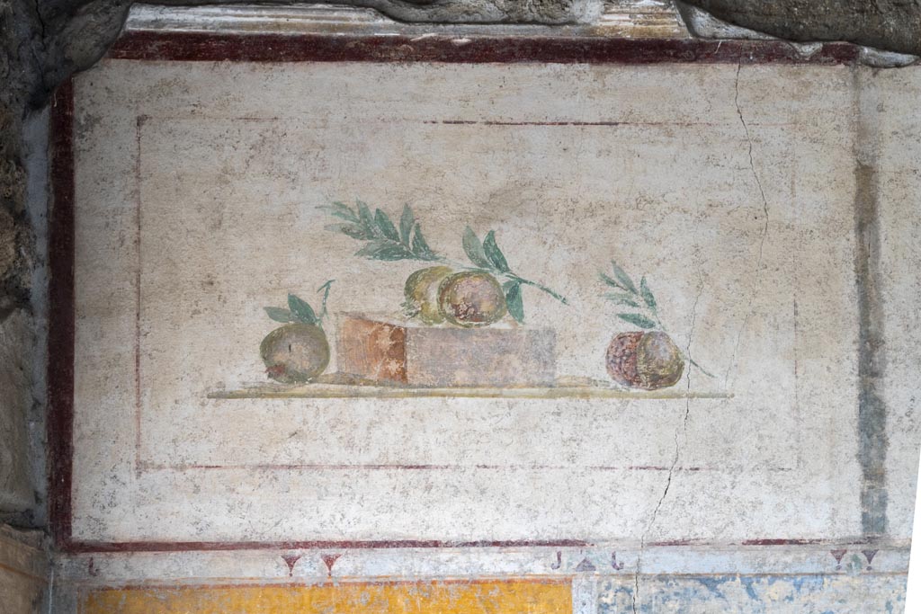 II.1.12 Pompeii. July 2021.
Triclinium, upper painted panel from south wall at east end with painting of pomegranates. Photo courtesy of Johannes Eber.
