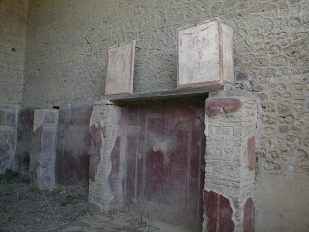 Pompeii. May 2005. Two pilaster paintings (at top on beam) from entrance fa�ade of II.1.12 Complesso dei Riti magici.
These were in III.3.6 and are reversed.
See Fr�hlich, T., 1991, Lararien und Fassadenbilder in den Vesuvst�dten. Mainz: von Zabern. (F16:p.312, T. 54/1 and 54/2).
Following the collapse in November 2010, these are believed to have been destroyed.