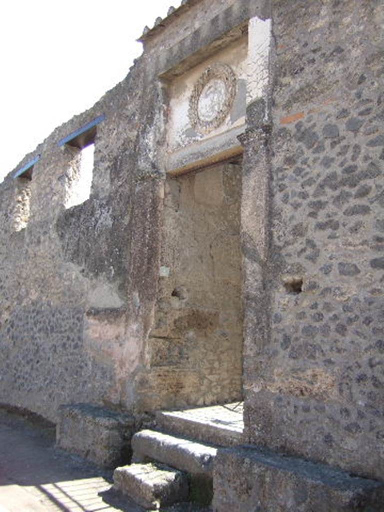 II.2.4 Pompeii. September 2005. 
Entrance doorway, looking east on Via dell’Abbondanza.
According to Della Corte, two electoral recommendations naming Messius Ampliatus, were found on the west (right) of the doorway –
Messius rog(at)     [CIL IV 7541]
Ampliatus r(ogat) cum liberties    [CIL IV 7542]
See Della Corte, M., 1965.  Case ed Abitanti di Pompei. Napoli: Fausto Fiorentino. (p.380-81)

According to PPP, the painted electoral inscription Gavium aed [CIL IV 7537] was also found on the right.
See Bragantini, de Vos, Badoni, 1981. Pitture e Pavimenti di Pompei, Parte 1. Rome: ICCD. (p.219)

According to Epigraphik-Datenbank Clauss/Slaby (See www.manfredclauss.de) these read –

A(ulum) Suettium Verum / aed(ilem) Messius rog(at)       [CIL IV 7541]
L(ucium) Ceium Secundum aed(ilem) / Ampliatus r(ogat) verecund[issimum cum] / libertis       [CIL IV 7542]
Gavium aed(ilem) o(ro) v(os) f(aciatis)       [CIL IV 7537]

