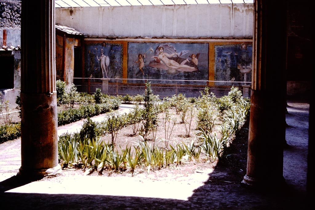 II.3.3 Pompeii. December 2005.Room 11, west panel of south wall of peristyle. Wall painting of fountain with garden, mask and birds.
