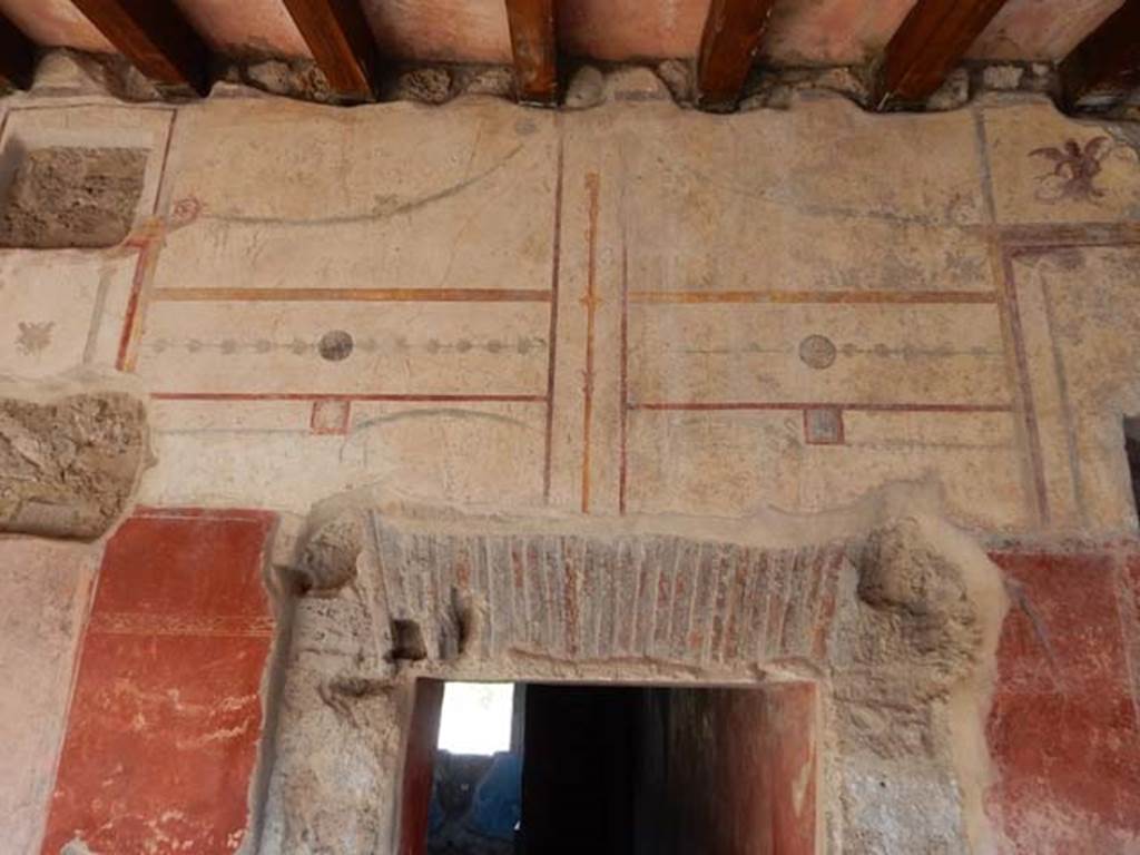 II.4.6 Pompeii. May 2017. Detail of south wall decoration above doorway to apodyterium.
Photo courtesy of Buzz Ferebee.
According to PPM, on top of the aedicula is a mermaid with fish in her hands.
See Carratelli, G. P., 1990-2003. Pompei: Pitture e Mosaici: Vol. III. Roma: Istituto della enciclopedia italiana, p. 211.