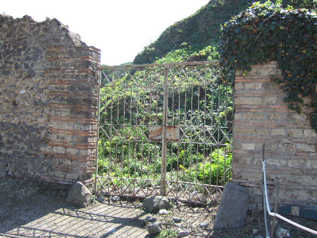 II.5.3 Pompeii. March 2009. Looking south towards wall on Via dell’Abbondanza, and blocked doorway of II.5.4 in wall.