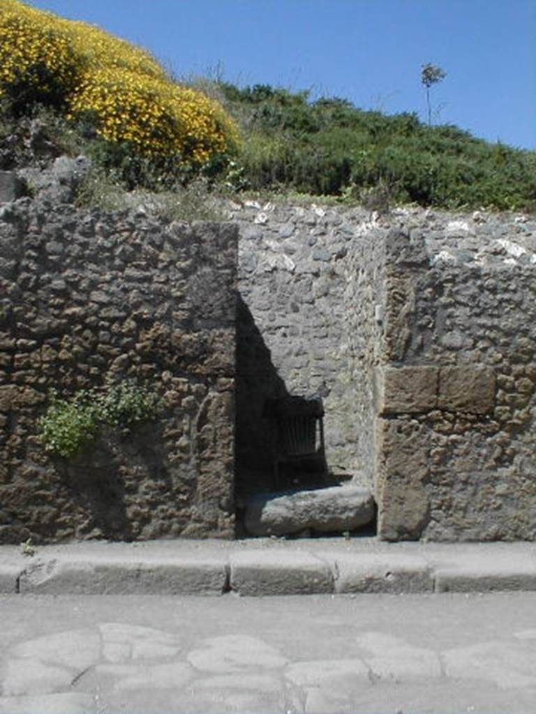 III.3.3 Pompeii. May 2005. Entrance doorway, partly excavated.
According to Garcia y Garcia, a bomb dropped during the bombardment of 19th September 1943 destroyed the fa�ade of III.3.4.
This led to the disintegration of the pilasters and doorposts of three entrances, (III.3.3, III.3.4 and III.3.5).
Also ruined were the dividing walls and the perimeter wall onto Via dell�Abbondanza for 26 x 5 metres.
In III.3.5 the internal walls were also destroyed.
See Garcia y Garcia, L., 2006. Danni di guerra a Pompei. Rome: L�Erma di Bretschneider. (p.53)
