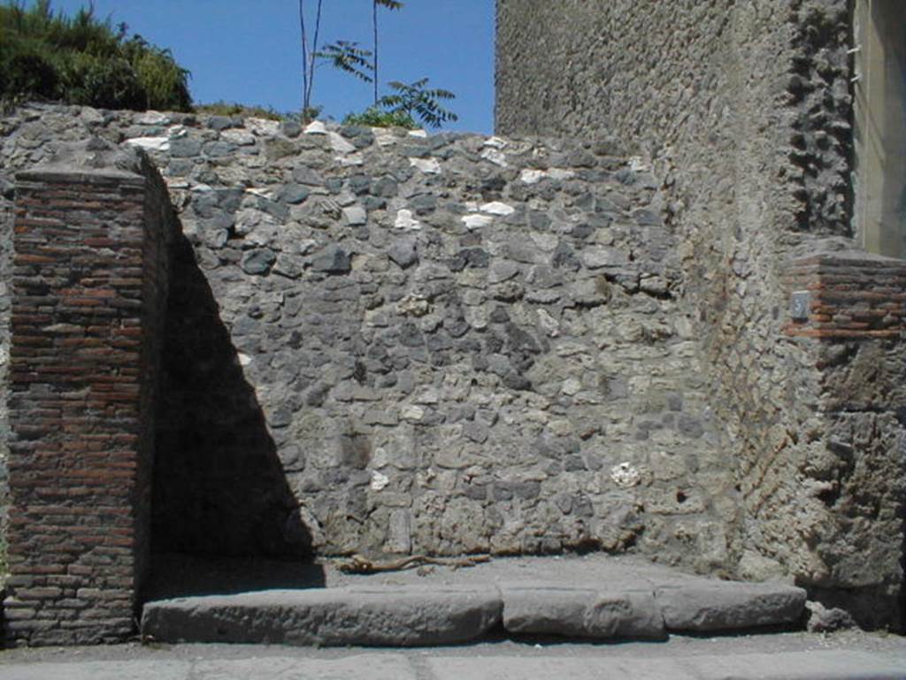III.3.5 Pompeii. May 2005. Blocked entrance doorway, partly excavated.

According to Garcia y Garcia, a bomb dropped during the bombardment of 19th September 1943 destroyed the fa�ade of this shop.
This led to the disintegration of the pilasters and doorposts of three entrances, (III.3.3, 4 and 5).
Also ruined were the dividing walls and the perimeter wall onto Via dell�Abbondanza for 26 x 5 metres.
In III.3.5 the internal walls were also destroyed.
See Garcia y Garcia, L., 2006. Danni di guerra a Pompei. Rome: L�Erma di Bretschneider. (p.53)
