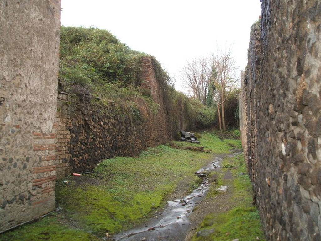 III.3 Pompeii. December 2004.     Roadway looking North.     Wall of III.4.a

 
