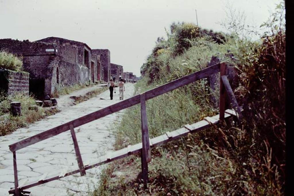 III.7 Pompeii. 1976. Looking west along Via dell�Abbondanza. The ramp was built as the only way up and over into the walled site. Photo by Stanley A. Jashemski.   
Source: The Wilhelmina and Stanley A. Jashemski archive in the University of Maryland Library, Special Collections (See collection page) and made available under the Creative Commons Attribution-Non Commercial License v.4. See Licence and use details. J76f0354

