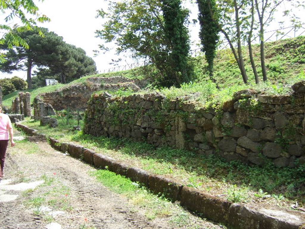 III.10.3 Pompeii. May 2006.  Looking east along Via Nola, along the front wall of the insula.