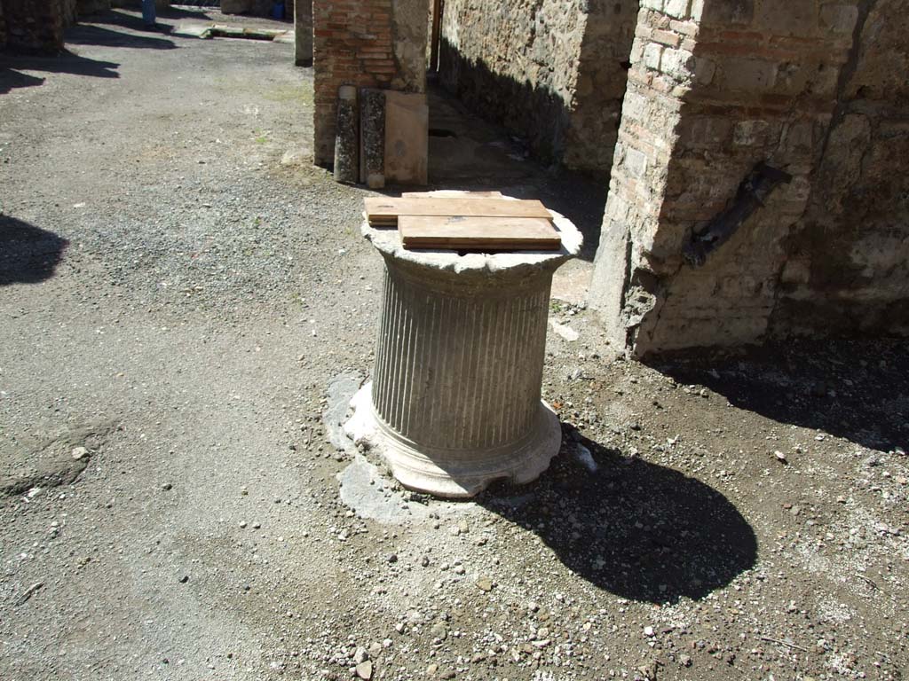 V.1.23 Pompeii. March 2009. Room “l” (L), marble puteal of the cistern in courtyard garden area.
On the wall to the right can be seen the remains of a large lead pipe that fed the cistern with rainwater from the roof.
