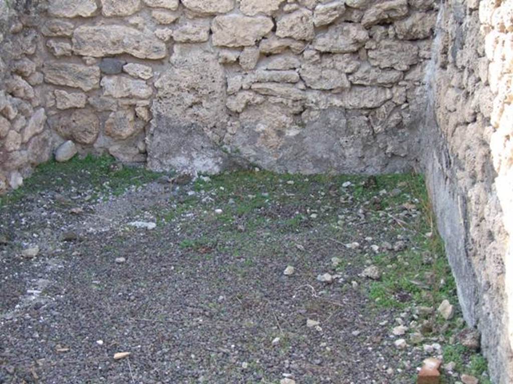V.2.7 Pompeii. December 2007. Room 2, west ala, from doorway.
According to PPM �
Mau mentioned, but without dwelling on them for any great length (and his are the only remaining descriptions) that rooms 2, 9 and the �living room� end of 10 were all decorated in the �candelabra� style. (Mau, RM 1894, p,39-43).
See Carratelli, G. P., 1990-2003. Pompei: Pitture e Mosaici, III. Roma: Istituto della enciclopedia italiana, (p.825).
Mau wrote �
The alae, (g and h, our rooms 2 and 9) have a simple decoration on a white background, which rather recalls the "candelabra" style contemporary to the Third style.
Standing in the left ala was the capital of a Doric column in tufa, without grooves, whereby in this house there are no columns.  
There was also a large weight of lava, elliptical in shape (0.42 long): a similar weight of travertine lies in "k".
(BdI, 1894, p.40).
