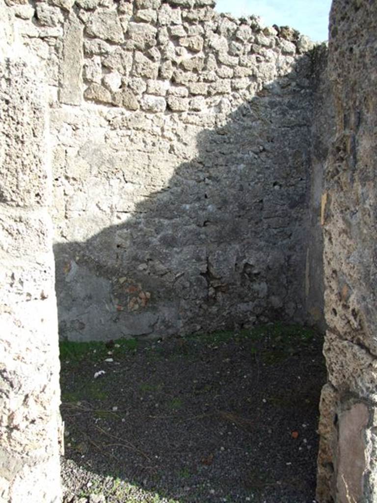V.2.7 Pompeii. December 2007. Doorway to room 8, room on east side of atrium.
Mau wrote �
This room was a pantry, with shelves on the walls, which were covered with rough/raw plaster.
This room would have been decorated in the IV Style on a simple white background.
Found in this room was a large weight of travertine.  
In this room (8 or "k") the bed was hanging from the right wall; to enlarge the place the stucco had been removed from the relative part of the entrance and back walls (instead of making the usual recesses).
(BdI, 1894, p.40).
According to PPM, 
�On the south wall, the zoccolo was edged with a green border, the middle zone was divided into two panels with purple �carpet border� edging with rectangles divided by diagonals, separated by a yellow border.�
